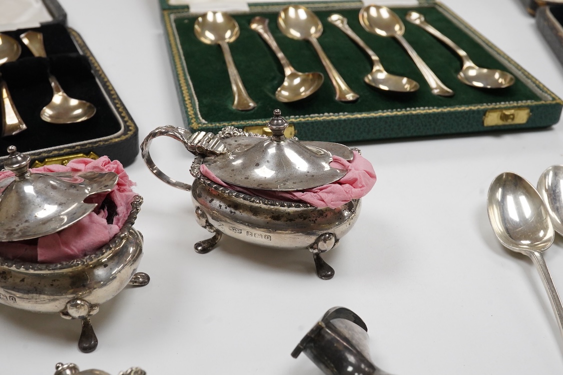 A collection of silver and white metal to include a 19th century Indian dressing table pot and cover chased with flowers, a three piece silver condiment set by Mappin and Webb with associated condiment spoon, three cased